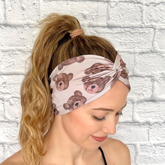 Woman with hair in ponytail wearing wide, twisted headband in brown with teddy bear print.