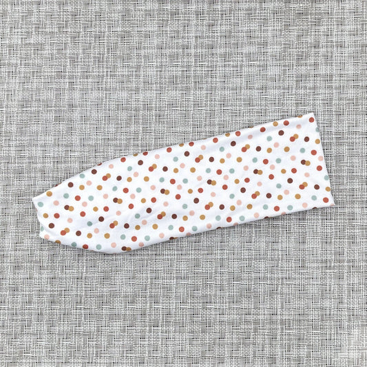 white headband with mint, orange, yellow, pink, and brown polka dots