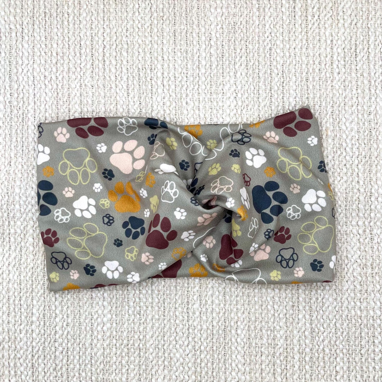 Wide, twisted headband in green with multi-color dog paw print.