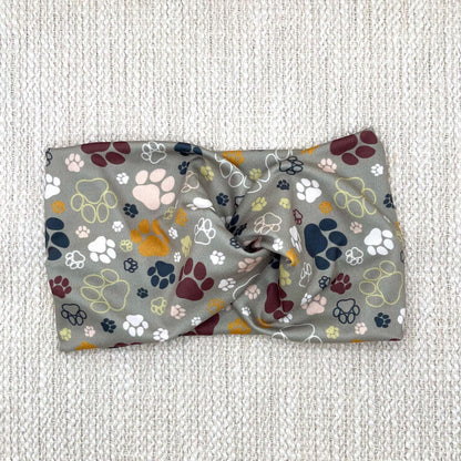 Wide, twisted headband in green with multi-color dog paw print.