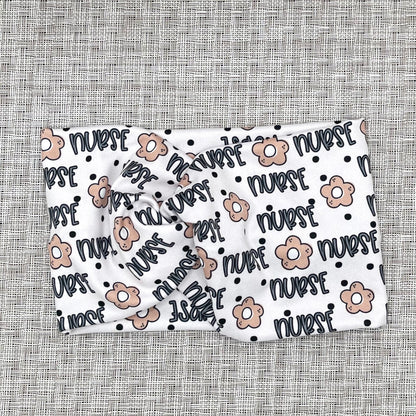 white headband with "nurse" and flower print in blue and tan