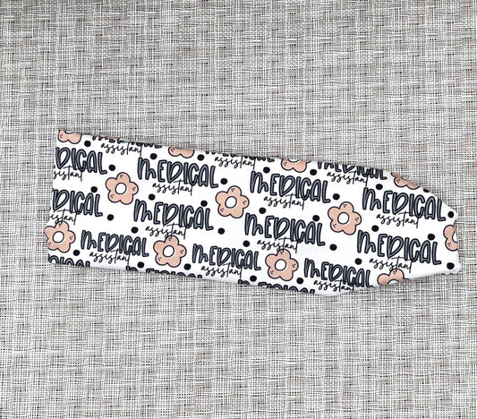 white headband with "medical assistant", flowers, and polka dot print in blue and tan