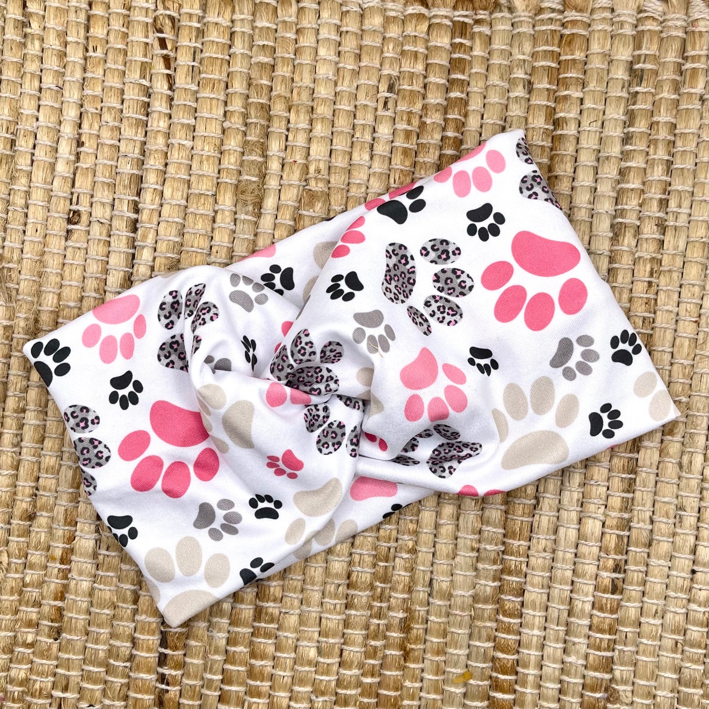 white headband with pink and gray dog paws